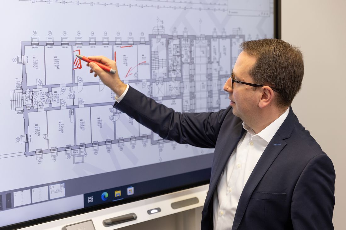 An architect marking up building plans on a SMART Board