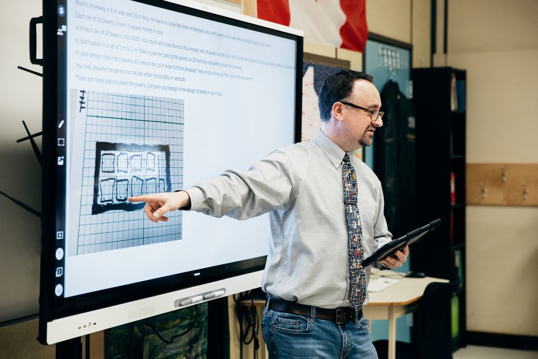 A teacher working through a lesson on a SMART interactive display