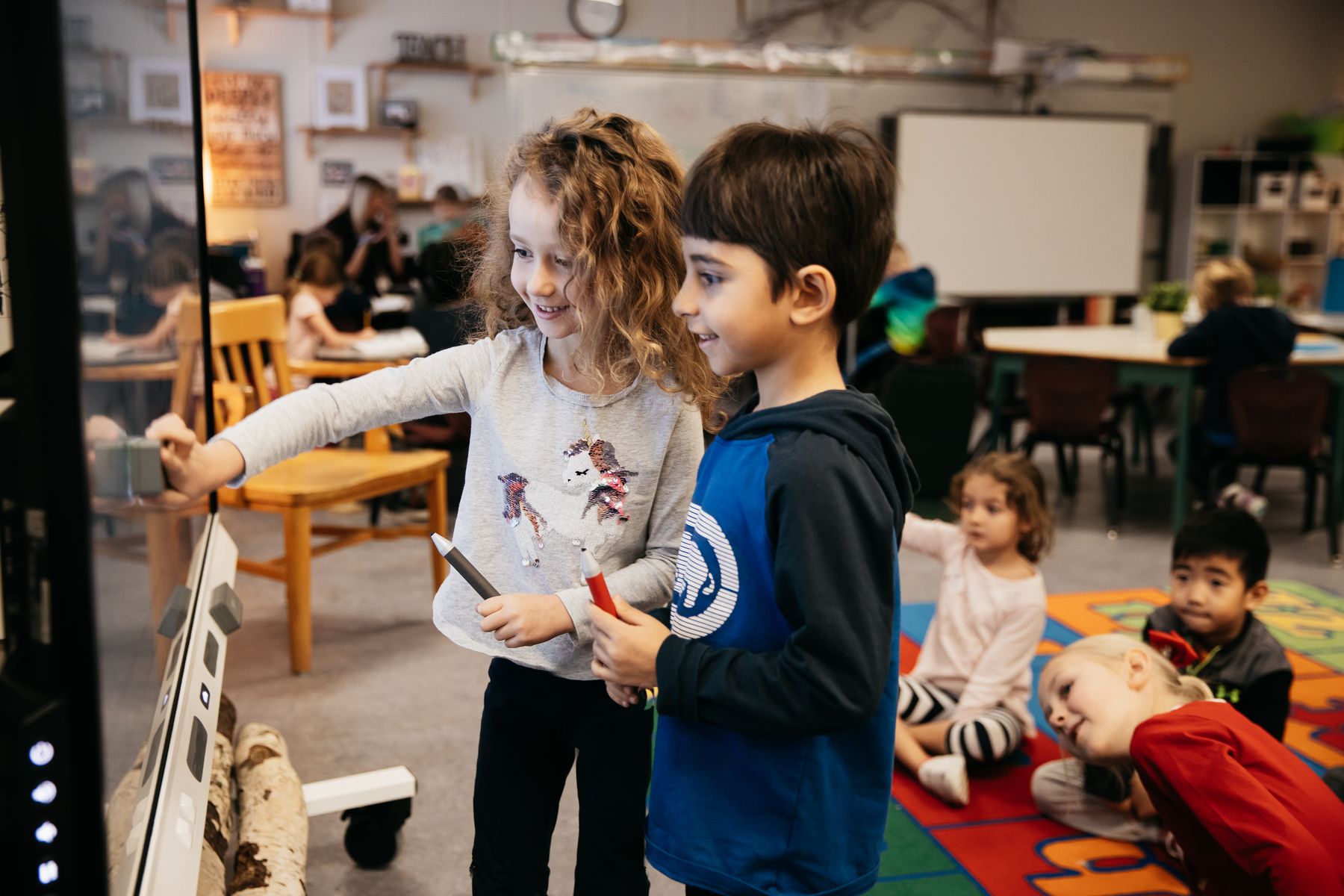 Students collaborating at a SMART interactive display in a Technetix-equipped classroom